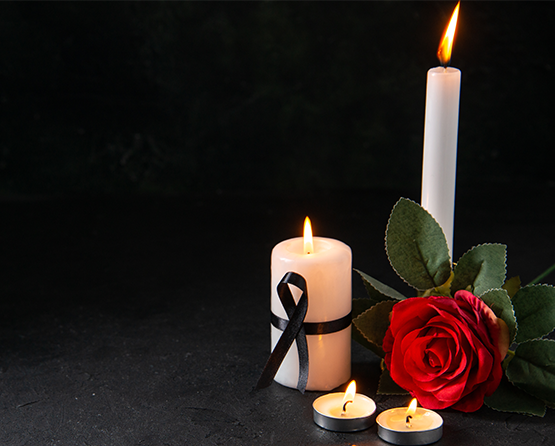 Zdjęcie żałone, przedstawiające świeczki i kwiat